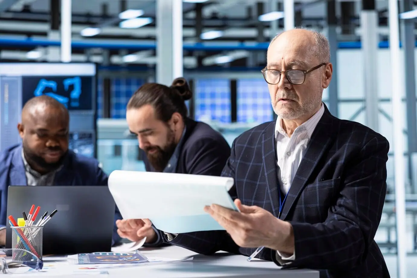 Старший акционер промышленного завода изучает документы, анализируя выручку.